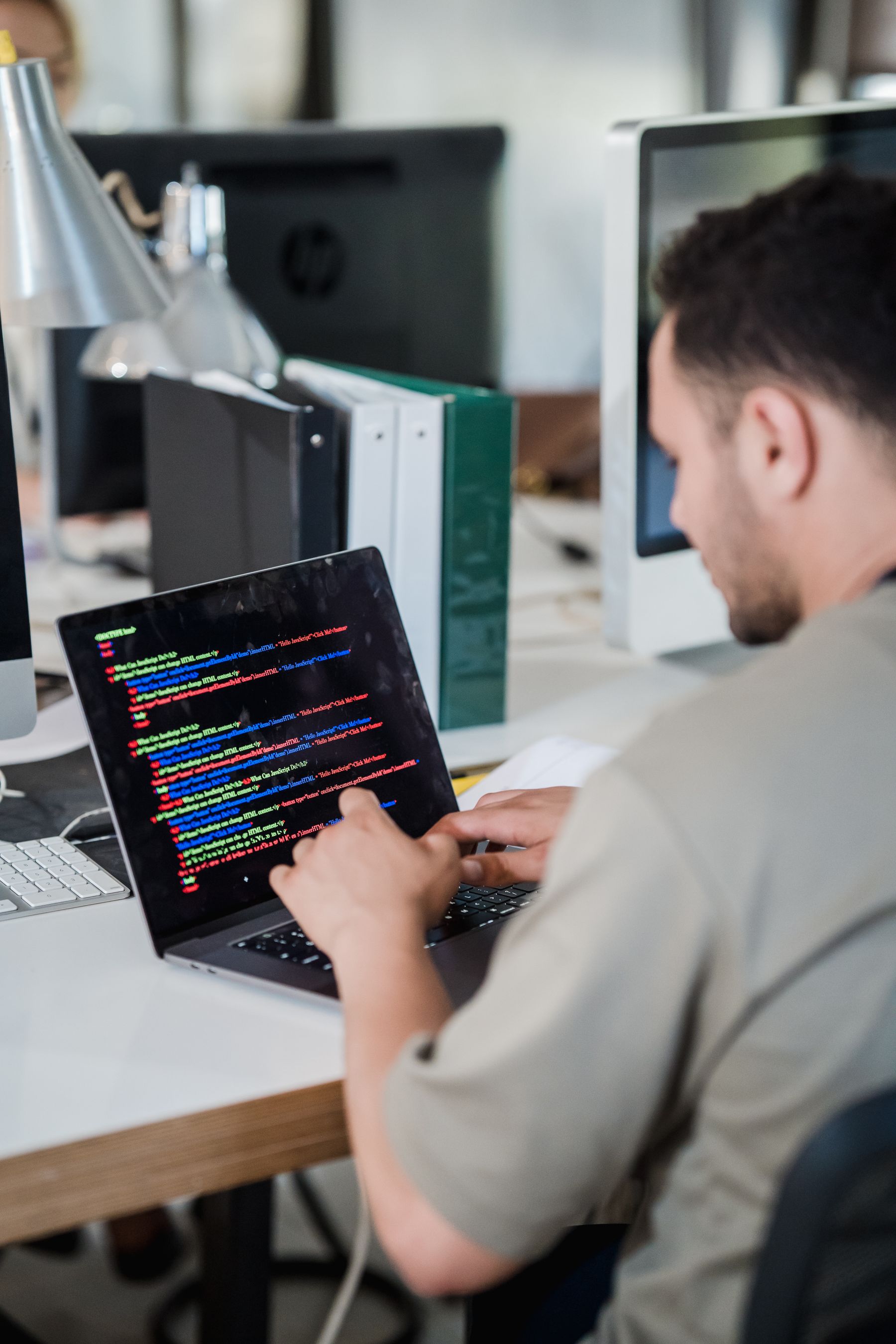 Software developer reviewing application code in a professional office workspace