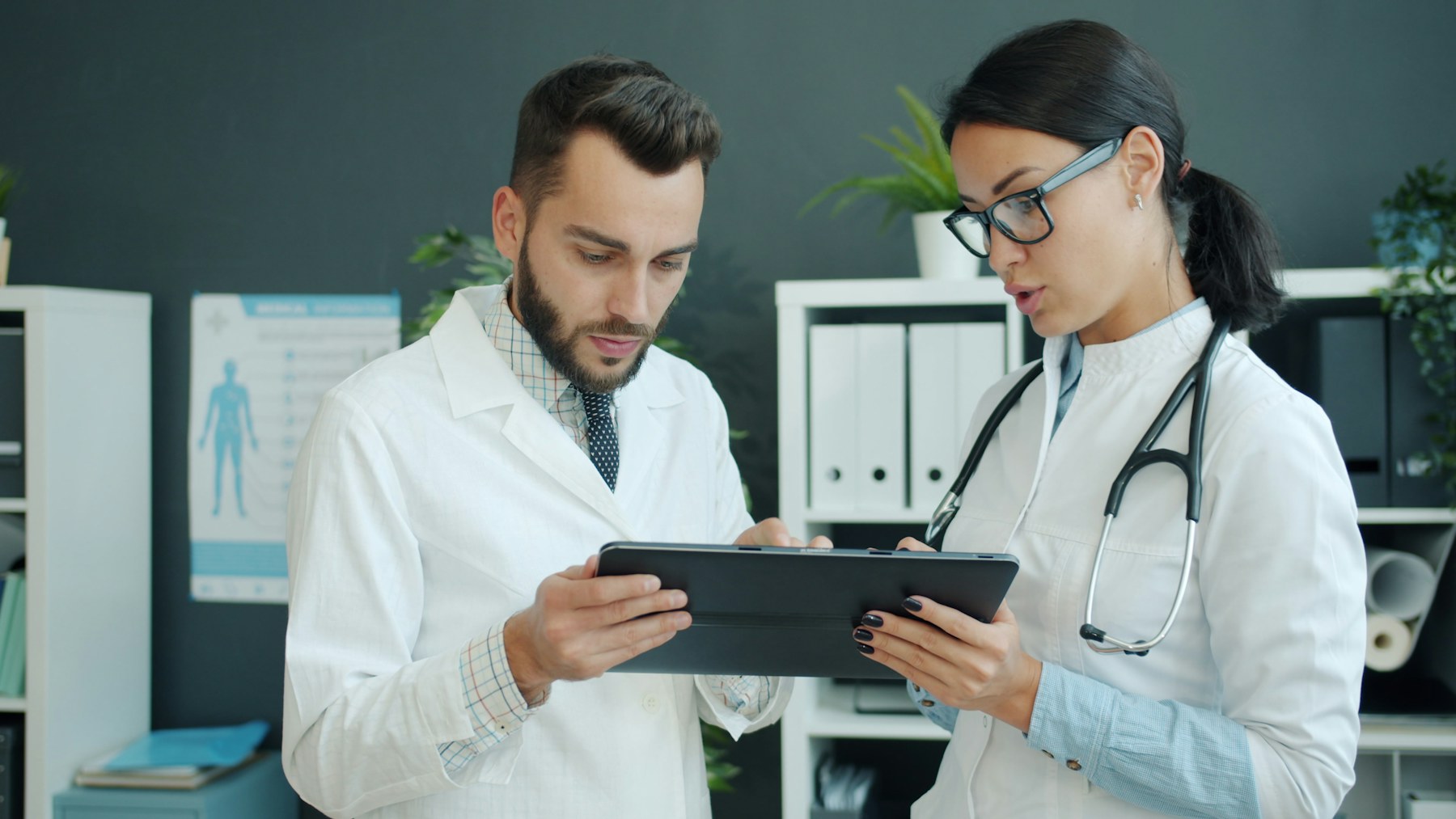 Clinicians using a tablet to coordinate healthcare workflows
