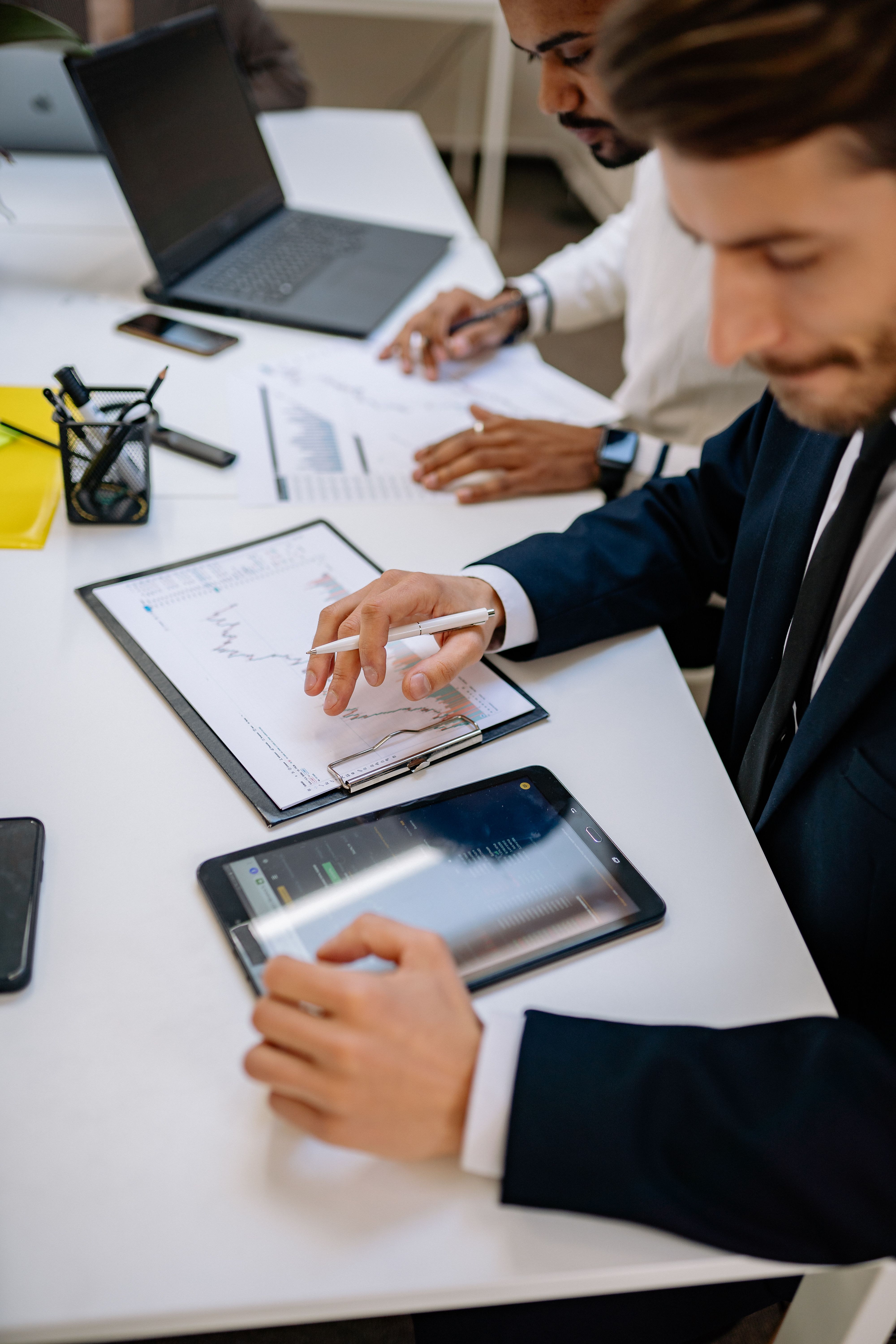 Business team reviewing workflow data on paper and a tablet