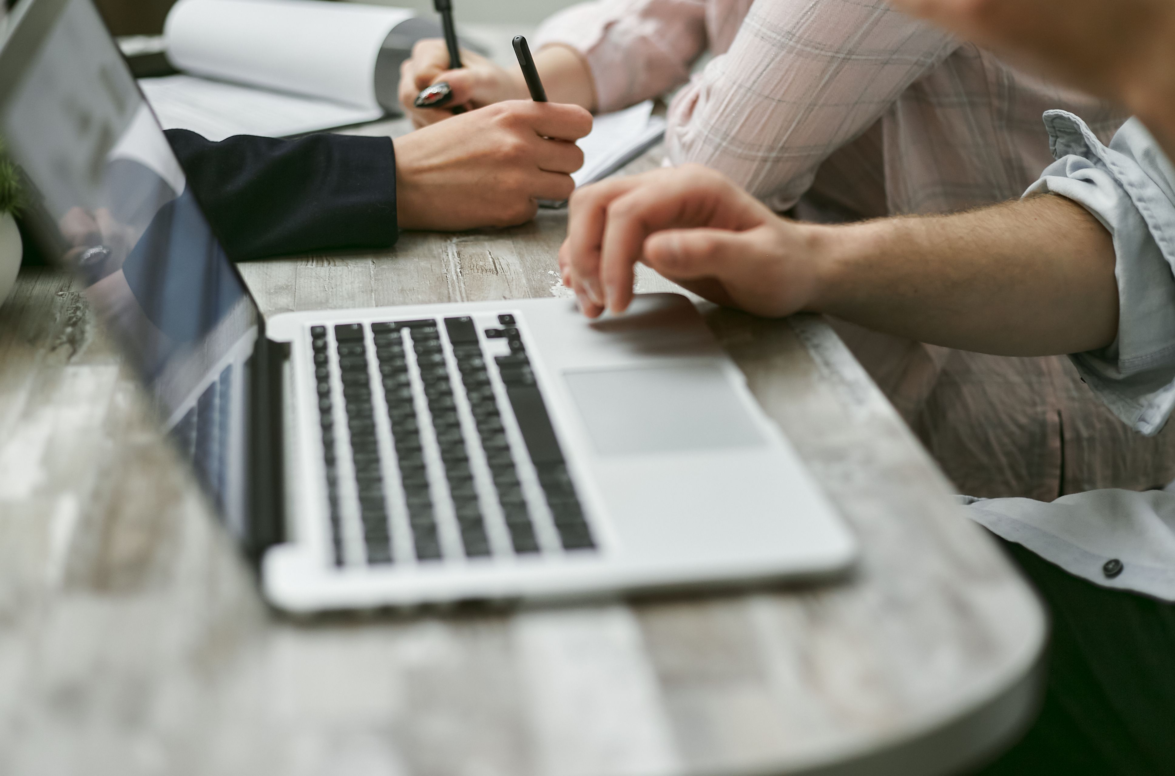 Hands working with a laptop and documents during an office planning session